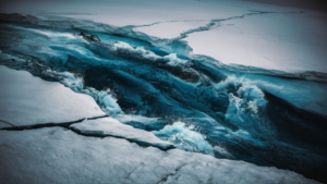 Dynamic aerial view of Antarctic Circumpolar Current cutting through ice shelves, demonstrating its powerful flow and impact on climate